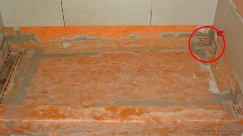 A Kerdi shower with a preformed corner circled in red that draws attention to the overlapping layers of waterproofing fabric