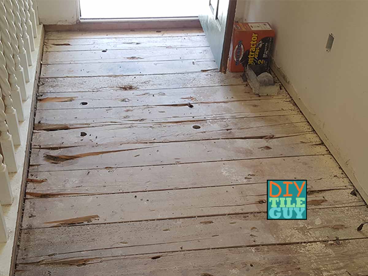 a plank subfloor in poor condition. The planks are not tongue & groove and have holes and cracks.
