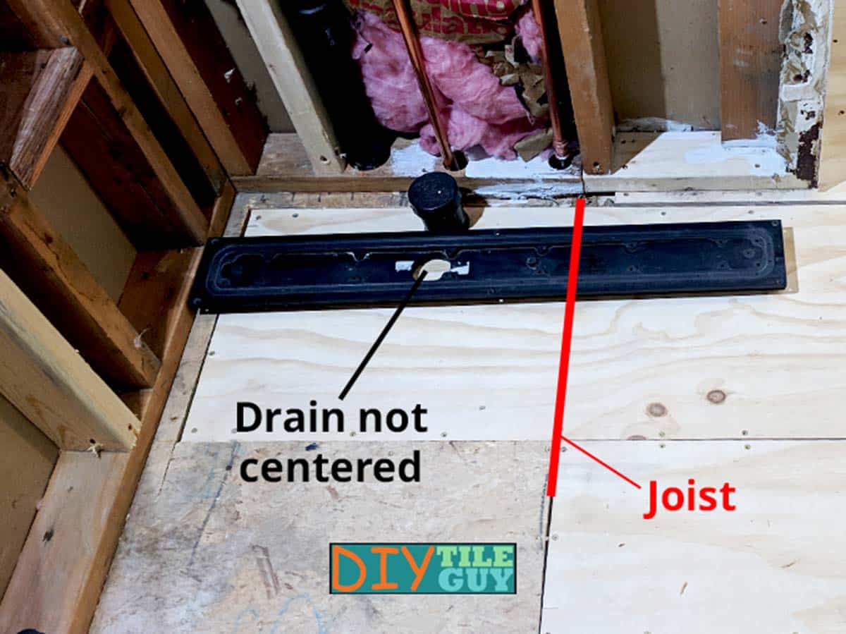 linear drain with an off-center drain outlet positioned in such a way as to miss the floor joist